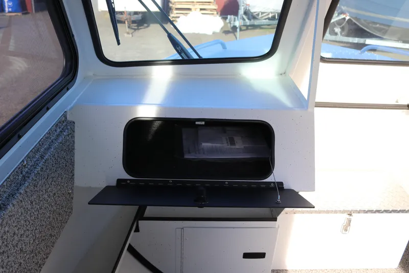 Slide: The Image of 2026 Alumaweld Intruder Outboard 22 interior with open storage compartment. - 21