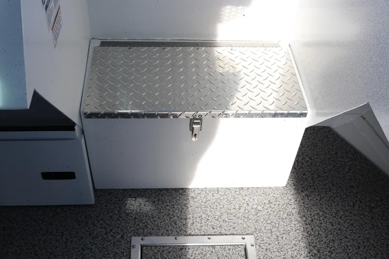 Slide: The Image of Alumaweld Intruder Outboard 22 (2026) storage compartment with diamond plate lid. - 22