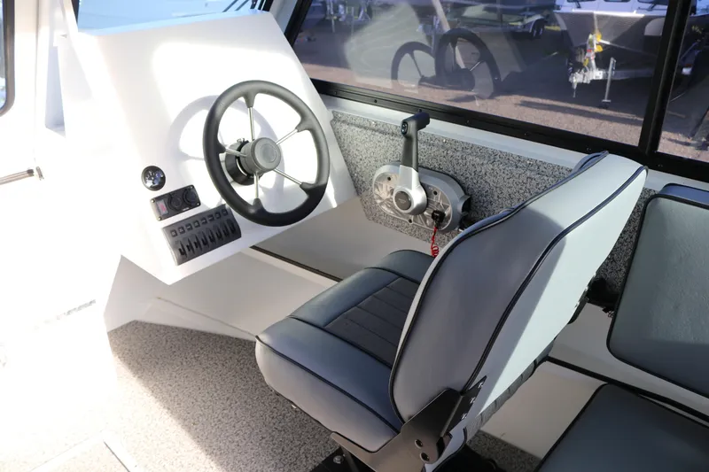 Slide: The Image of 2026 Alumaweld Intruder Outboard 22 boat interior with steering wheel and control panel. - 28