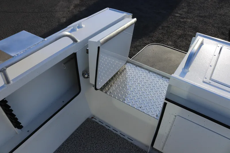 Slide: The Image of 2026 Alumaweld Intruder Outboard 22 boat interior with diamond plate flooring and storage compartments. - 8