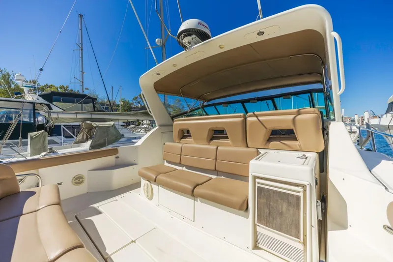 Slide: The Image of 2000 Tiara Yachts 4000 Express with tan seating, docked under clear blue sky. - 12