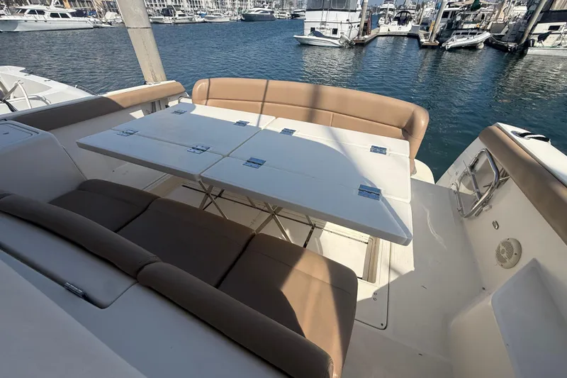 Slide: The Image of 2000 Tiara Yachts 4000 Express deck with seating and table, docked at marina. - 14
