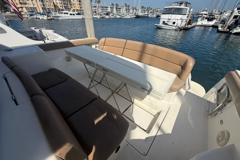 Slide: The Image of 2000 Tiara Yachts 4000 Express with spacious seating and table in marina setting. - 15