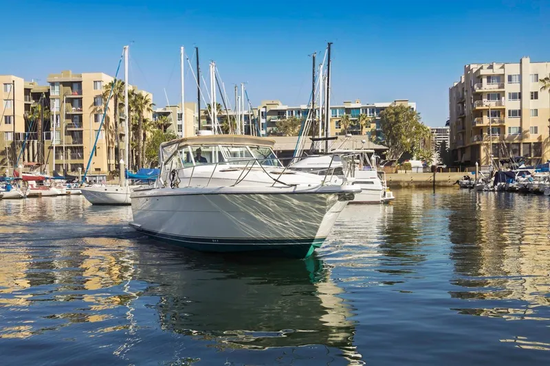 Slide: The Image of 2000 Tiara Yachts 4000 Express in marina, surrounded by modern buildings and sailboats. - 2