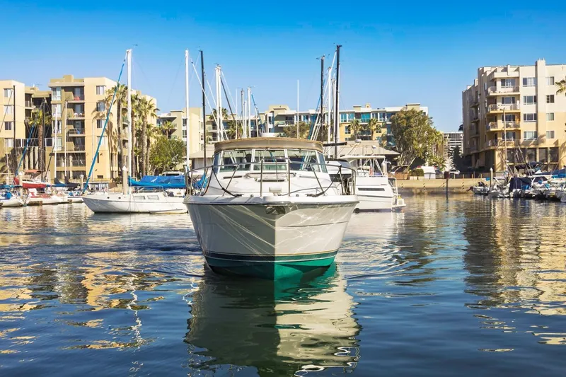 Slide: The Image of 2000 Tiara Yachts 4000 Express in marina, surrounded by modern buildings and sailboats. - 3