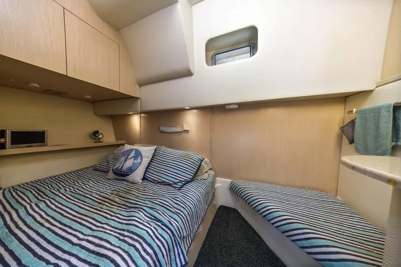 Slide: The Image of Cozy cabin interior of 1995 Tiara Yachts 4000 Express with striped bedding and nautical decor. - 31