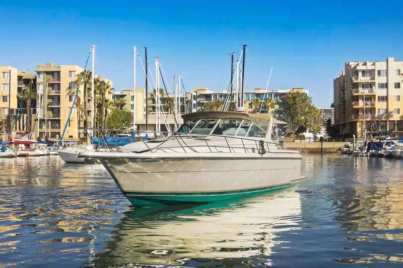 Slide: The Image of 2000 Tiara Yachts 4000 Express in marina, surrounded by modern buildings and sailboats. - 4