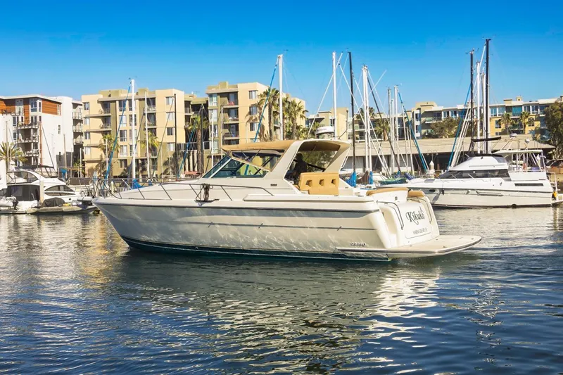 Slide: The Image of 2000 Tiara Yachts 4000 Express in marina, surrounded by modern buildings and other boats. - 5