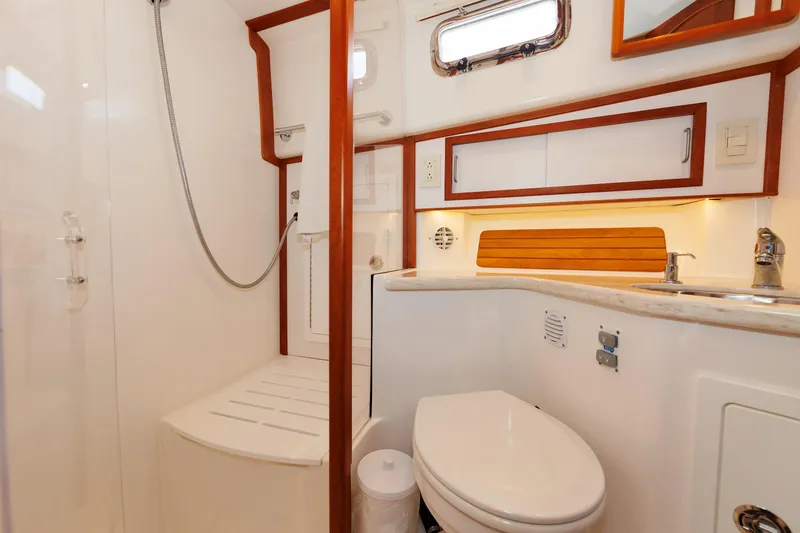 Slide: The Image of Luxurious bathroom in 2016 Sabre 42 Fly Bridge Sedan yacht, featuring modern fixtures and elegant wood accents. - 18