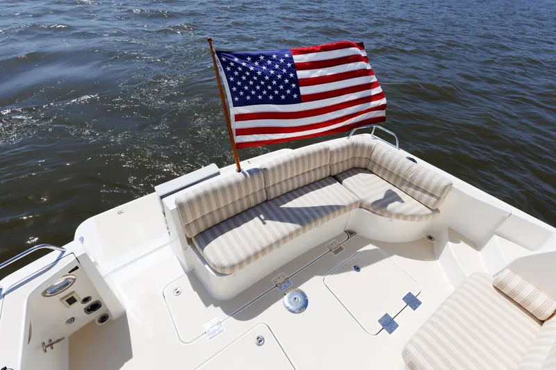 Slide: The Image of 2016 Sabre 42 Fly Bridge Sedan with American flag on deck, cruising on water. - 23