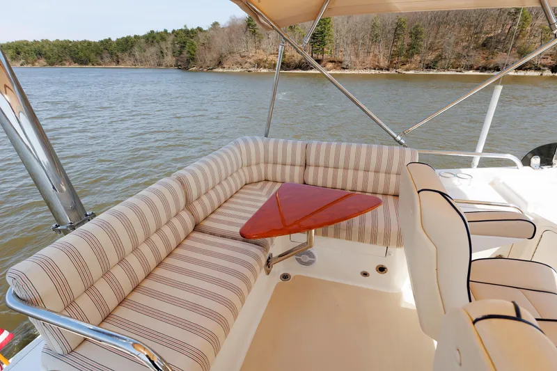 Slide: The Image of Flybridge seating area on 2016 Sabre 42 Fly Bridge Sedan yacht with striped cushions and triangular table. - 24