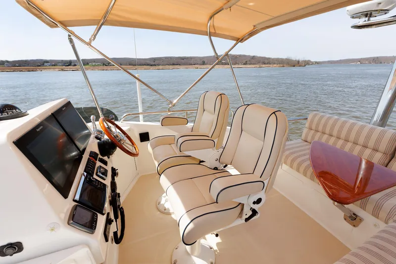 Slide: The Image of Flybridge of 2016 Sabre 42 Fly Bridge Sedan with helm, seating, and water view. - 4