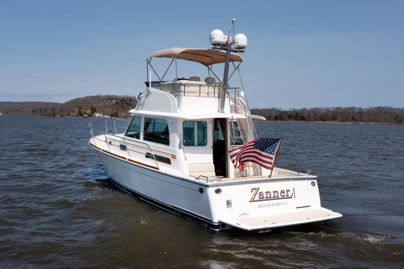 Slide: The Image of 2016 Sabre 42 Fly Bridge Sedan cruising on a lake with American flag. - 40