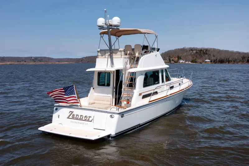 Slide: The Image of 2016 Sabre 42 Fly Bridge Sedan on water, American flag, scenic background. - 41