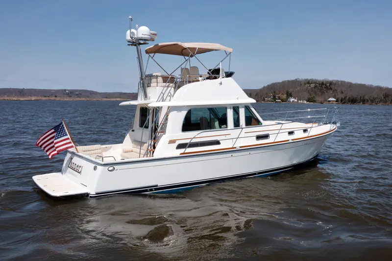 Slide: The Image of 2016 Sabre 42 Fly Bridge Sedan yacht on calm waters with American flag. - 42
