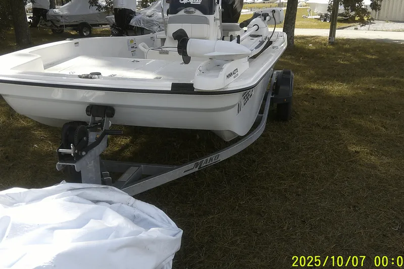 Slide: The Image of 2024 Mako Pro Skiff 15 CC boat on trailer, parked on grass. - 10