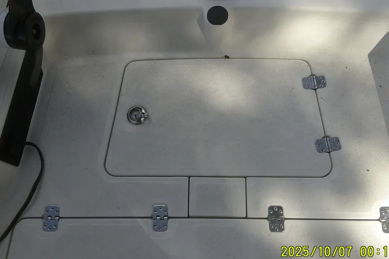 Slide: The Image of 2024 Mako Pro Skiff 15 CC deck with storage hatch and hinges. - 17