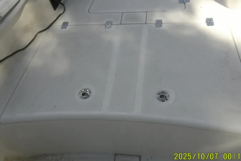 Slide: The Image of 2024 Mako Pro Skiff 15 CC deck with storage hatches and cleats. - 19