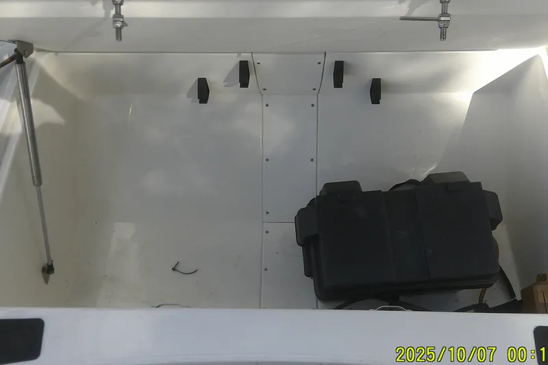 Slide: The Image of 2024 Mako Pro Skiff 15 CC storage compartment with black box and hydraulic support. - 20