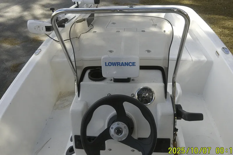 Slide: The Image of 2024 Mako Pro Skiff 15 CC boat console with steering wheel and Lowrance device. - 23