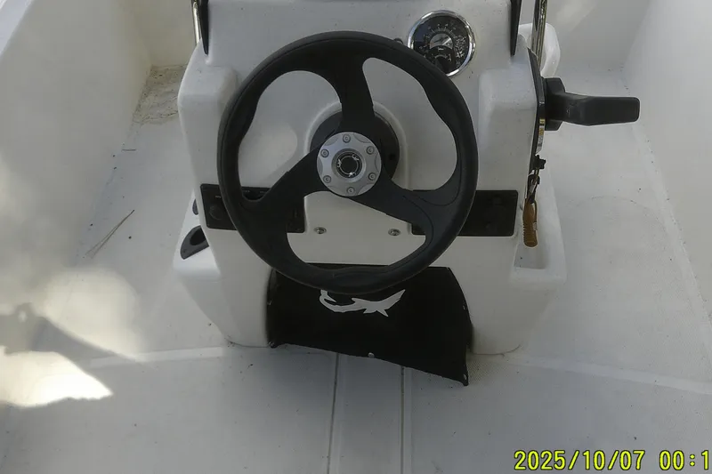 Slide: The Image of Steering console of 2024 Mako Pro Skiff 15 CC boat, featuring a black wheel. - 24