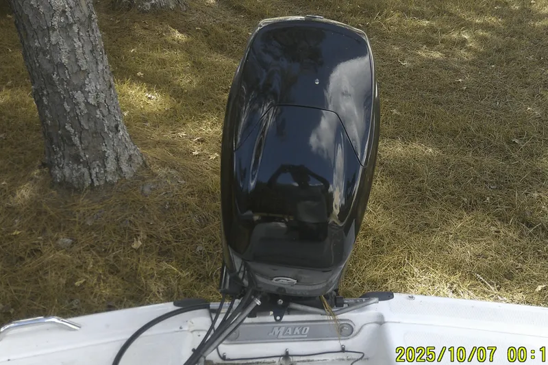 Slide: The Image of 2024 Mako Pro Skiff 15 CC boat engine, parked on grassy terrain. - 29