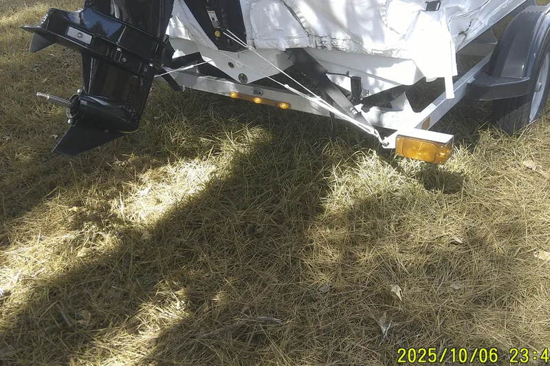Slide: The Image of 2024 Mako Pro Skiff 15 CC boat trailer on grassy ground. - 4