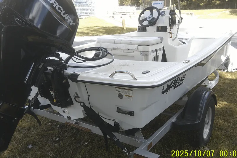 Slide: The Image of 2024 Mako Pro Skiff 15 CC boat on trailer with Mercury outboard motor. - 7