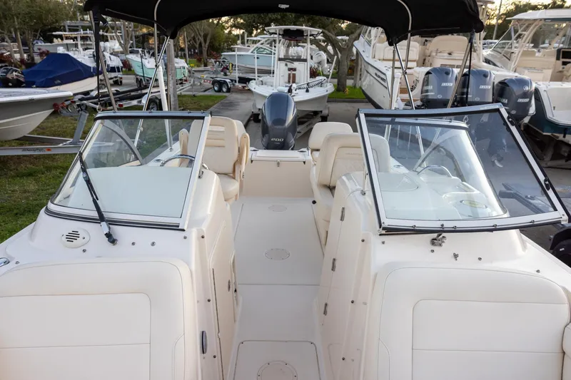 Slide: The Image of 2021 Grady-White Freedom 215 boat interior with seating and windshield, docked among other boats. - 13