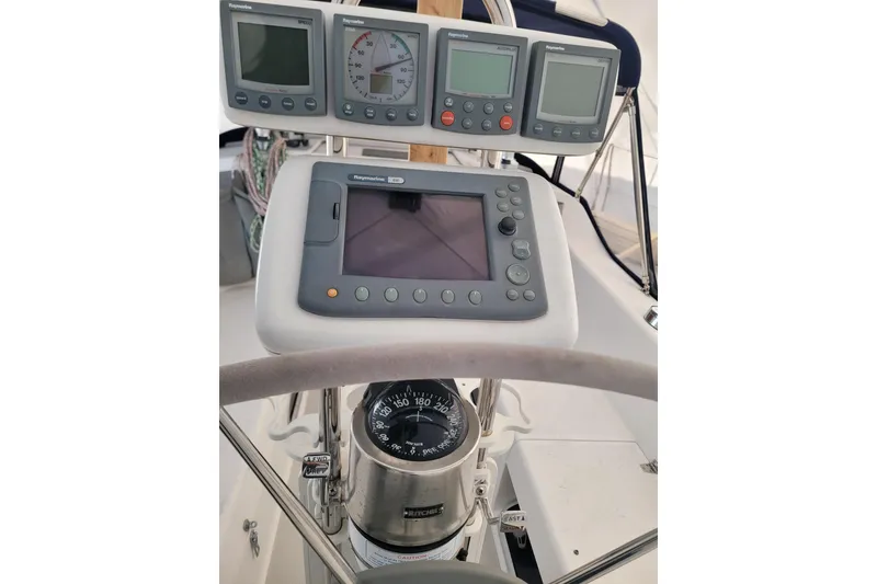Slide: The Image of Cockpit instruments of a 2006 Catalina 320 sailboat, featuring navigation displays and compass. - 15