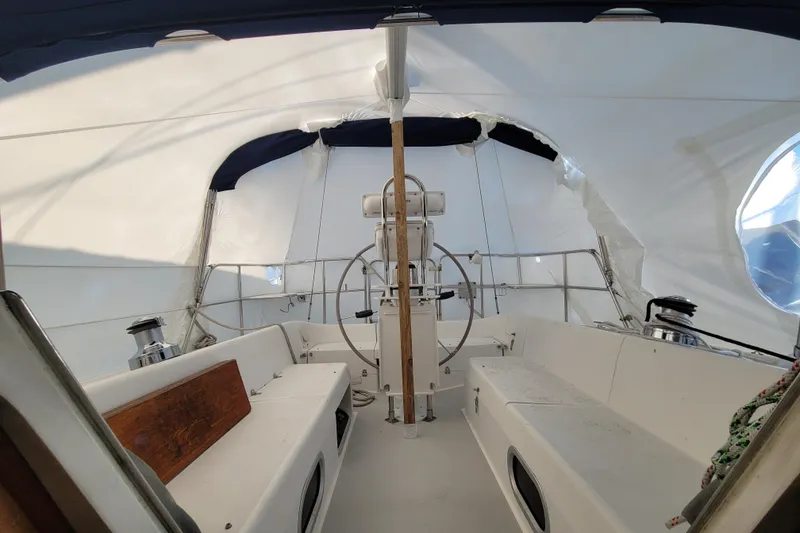 Slide: The Image of Cockpit of a 2006 Catalina 320 sailboat with white canopy and steering wheel. - 18