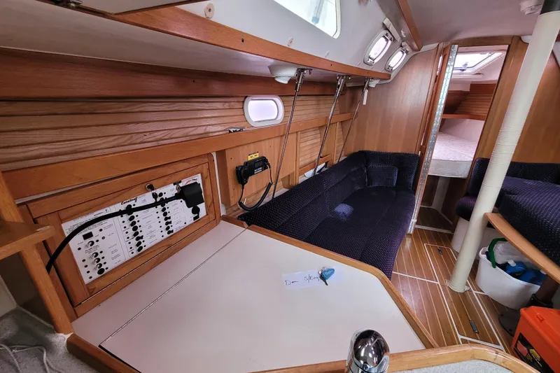 Slide: The Image of Interior of a 2006 Catalina 320 sailboat with wood paneling and seating area. - 22