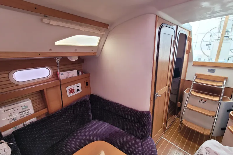 Slide: The Image of Interior of a 2006 Catalina 320 sailboat with cozy seating and wooden accents. - 26