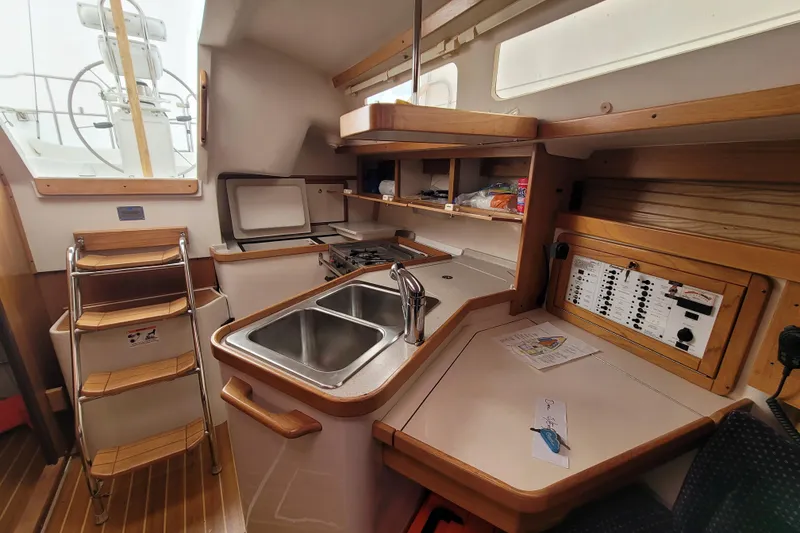 Slide: The Image of Interior of a 2006 Catalina 320 sailboat galley with sink, stove, and navigation panel. - 27
