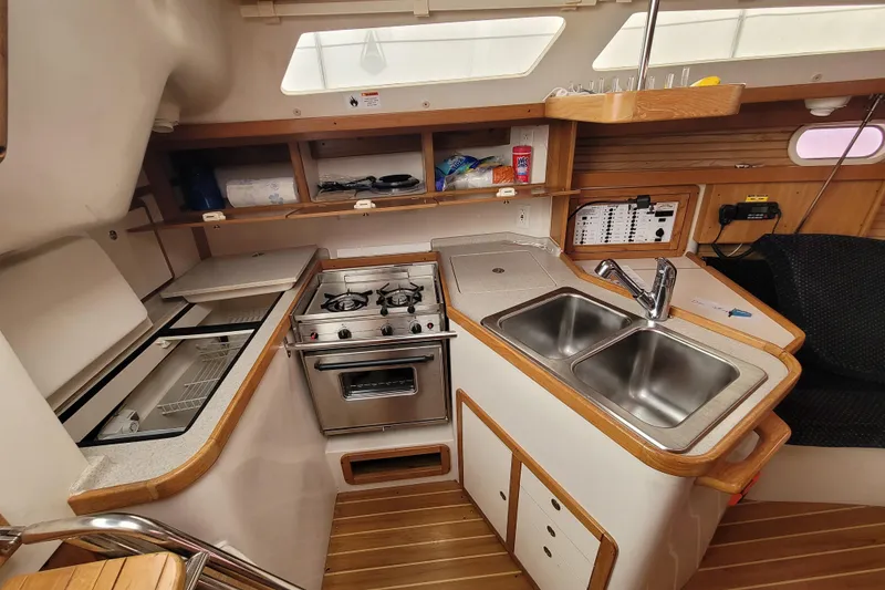 Slide: The Image of Compact kitchen in a 2006 Catalina 320 sailboat with stove, sink, and storage. - 28