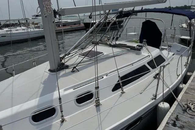 Slide: The Image of 2006 Catalina 320 MkII sailboat docked at marina, showcasing sleek design and rigging. - 3