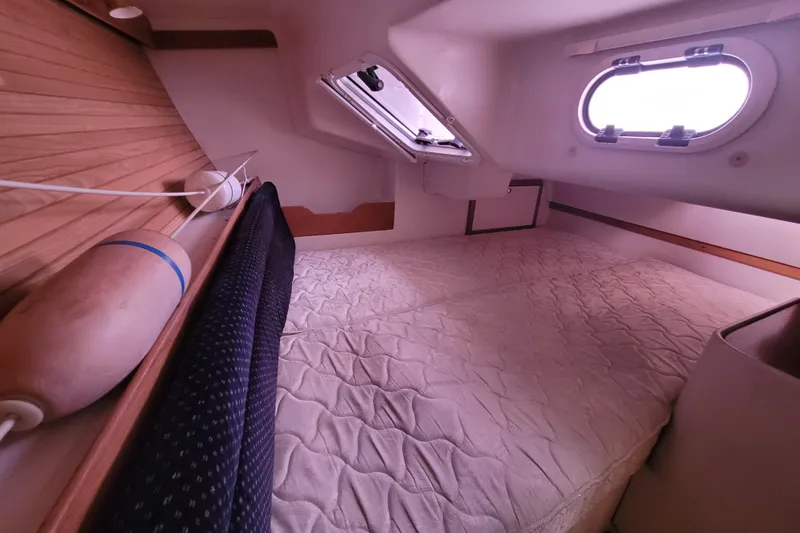 Slide: The Image of Cozy cabin interior of 2006 Catalina 320 sailboat with bed and porthole window. - 31