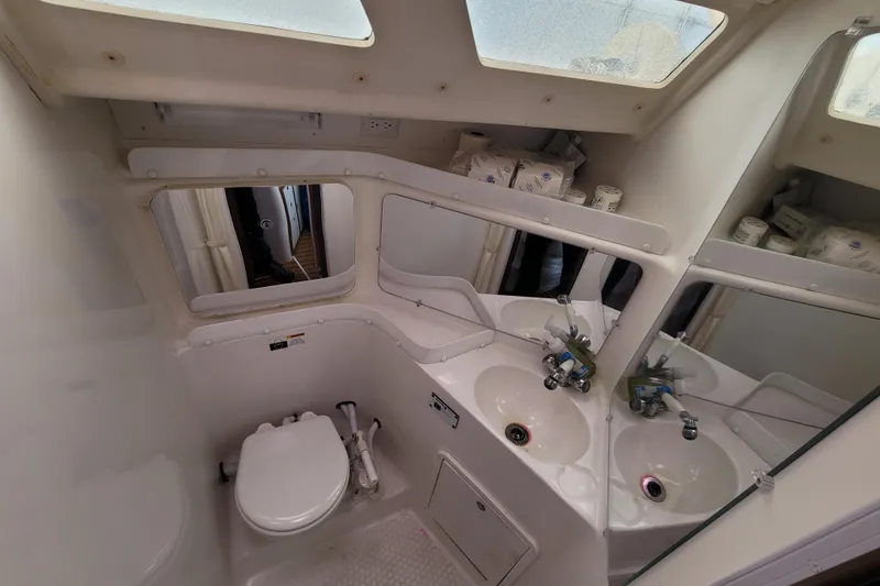 Slide: The Image of Bathroom interior of a 2006 Catalina 320 yacht, featuring dual sinks and mirrors. - 32