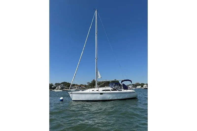 Slide: The Image of 2006 Catalina 320 MkII sailboat on calm water under clear blue sky. - 4