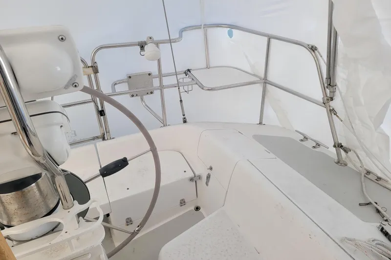 Slide: The Image of Interior view of a 2006 Catalina 320 sailboat cockpit with steering wheel and seating. - 9