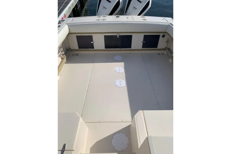 Slide: The Image of 1992 Grady-White Dolphin 251 boat deck with storage compartments and twin outboard motors. - 4