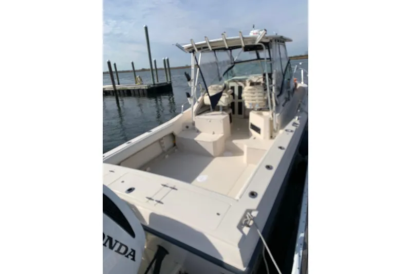 Slide: The Image of 1992 Grady-White Dolphin 251 boat docked, featuring spacious deck and seating area. - 6