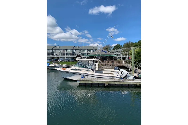 Slide: The Image of 1992 Grady-White Dolphin 251 boat docked at marina under blue sky. - 7