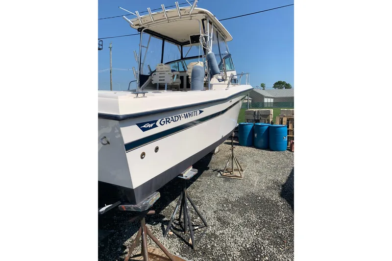 Slide: The Image of 1992 Grady-White Dolphin 251 boat on stands, outdoor setting. - 9