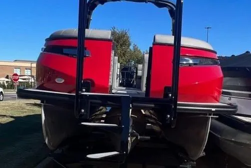 Slide: The Image of Red 2023 Montara Naxos boat with dual seating, parked outdoors. - 3