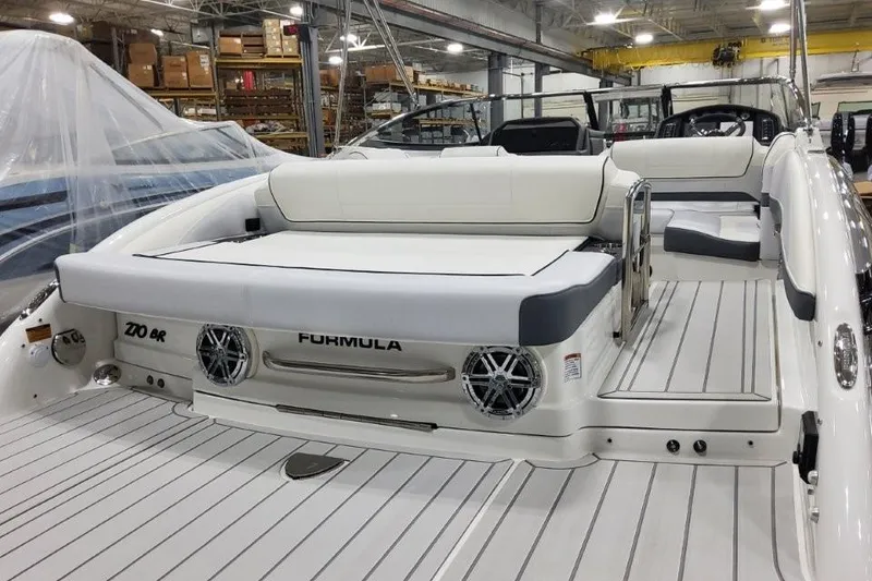 Slide: The Image of 2026 Formula 270 Bowrider boat interior with white seating and sleek design in a showroom. - 8