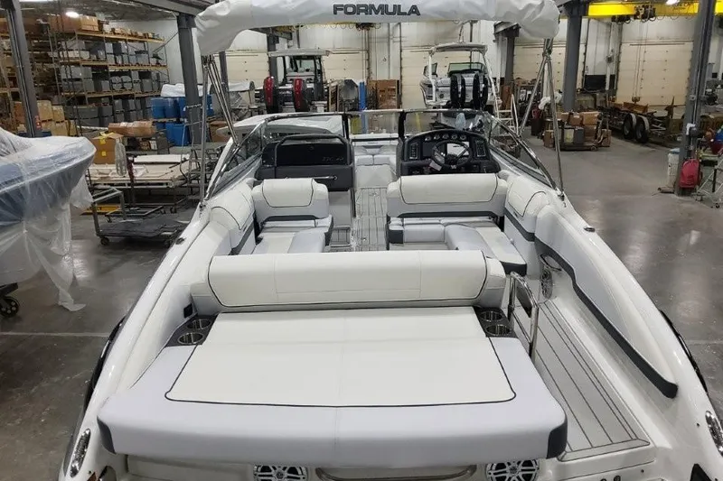 Slide: The Image of 2026 Formula 270 Bowrider boat interior with white seating in a warehouse setting. - 9
