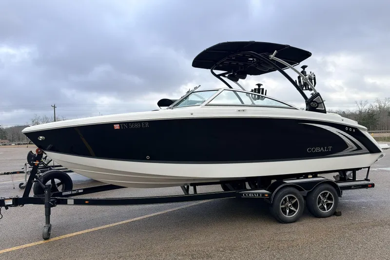 Slide: The Image of 2019 Cobalt R5 Surf boat on trailer, parked outdoors under cloudy sky. - 37