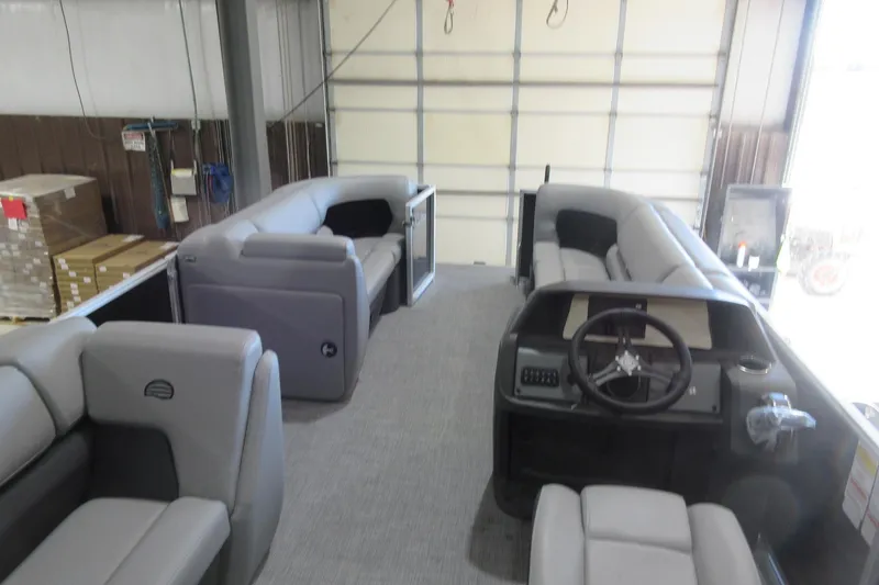 Slide: The Image of 2026 Sun Tracker Party Barge 20 DLX interior with plush seating and steering console. - 8