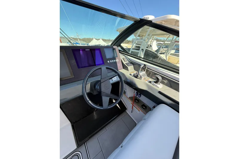Slide: The Image of 2023 Aviara AV32 I/O boat cockpit with modern steering and control panel. - 12